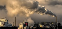 Chemical refinery with industrial stacks emitting steam and emissions